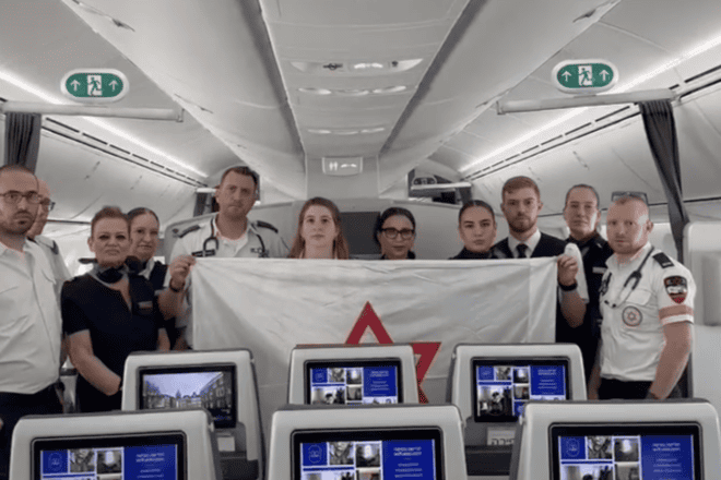 Members of Magen David Adom on El Al plane en route to Amsterdam to bring back Israeli citizens. Source: Screenshot.